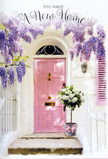 This scene portrays a welcoming Chislehurst doorway that seems purpose-made for a housewarming card or new home bouquet. At its heart is a soft pink front door, painted in a soothing, chalky blush that radiates calm and friendliness. The door sits within a whitewashed façade whose faintly uneven texture catches pockets of light and shadow, adding depth and a hint of character, as if this home has a story that is only just beginning. Above, strands of wisteria cascade down from an unseen trellis, their lavender blossoms falling in loose, scented clusters. Each bloom is a small burst of purple, tapering to pale lilac at the tips, giving the impression of a natural curtain that frames the entrance. To one side, a matching pastel shutter subtly echoes the door's tone, tying the look together in a pastel palette that would not feel out of place near Chislehurst's leafy lanes and hidden garden squares. On the stone step, positioned close to the threshold as though recently delivered, sits a rounded metal bucket in a soft, weathered grey. From this bucket spills a generous arrangement of white and cream roses, their petals layered and full, accompanied by delicate stems of fresh green foliage that soften the composition. A pale pink ribbon wraps around the bucket, tied carefully in a neat bow that pools slightly onto the step. The overall feeling is one of gentle joy and reassurance: the kind of thoughtful floral gesture friends or family might have sent to celebrate a new address, to fill a freshly painted hallway with fragrance, and to say, in the quiet language of flowers, that this place is truly home.